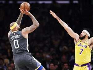 UMISKOR sa perimeter si Golden State Warriors’ DeMarcus Cousins sa kabila ng mahigpit na depensa ni Los Angeles Lakers’ JaVale McGee sa kaagahan ng kanilang laro sa NBA. (AP)
