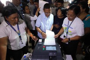 BAKIT AYAW? Ipinapasok ni dating Vice President Jejomar Binay ang kanyang balota sa VCM sa San Antonio National High School sa Makati City kaninang umaga. (JANSEN ROMERO)