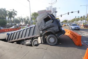 HEAVYGAT! Makikita sa larawan ang nabalahaw na 14-wheeler-truck, na kargado ng buhangin, nang malubog sa limang talampakang butas sa Remedios Street corner Roxas Boulevard, sa Maynila nitong Linggo. (ALI VICOY)