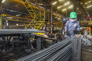 PABABA Binubungkos ng obrero ang mga steel rods sa isang pabrika sa Valenzuela City. (KEVIN TRISTAN ESPIRITU)