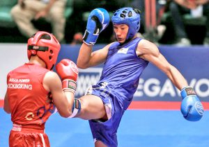 NAGAWANG puntusan ni Jerry Olsim (kanan) ang karibal tungo sa gintong medalya para sa Philippine Kickboxing Team sa 30th Southeast Asian Games. (RIO DELUVIO)