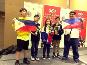 Makikita sa larawang ito si Singapore based Arcege Tan Castillo (overall 23rd place in the Boys Under 11 who totes 4.5 points); Jericho Winston Cu (overall 8th place in the Boys 9 and under 5.5 points); Jillianne Cait Keesha Micarsos (overall 10th place in the Girls Under 7); Ivan Travis Cu (overall 2nd place in the Boys 10 and under) and Arena Grandmaster Almario Marlon Quiroz Bernardino Jr. (Coach).